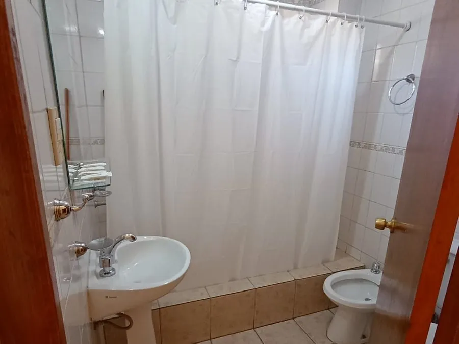 Baño privado con lavatorio, ducha con cortina blanca y bidet