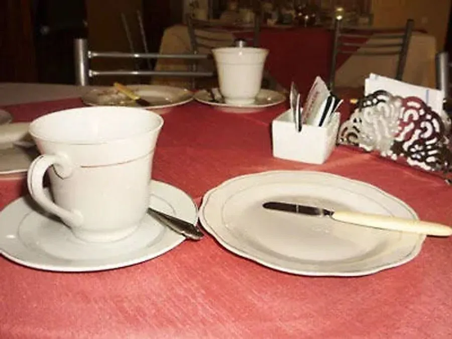 Taza de café y plato servidos en el desayuno